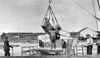Lowering supplies in cargo net, H. B. C. depot, Charlton Island, NU, about 1925