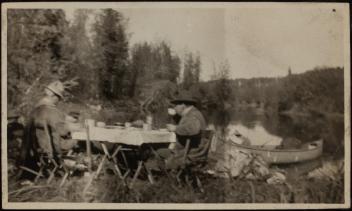 N. H. Bacon and Robert L. Ridley drinking in the wilderness, Athabasca River?, Alberta?, 1913-1920