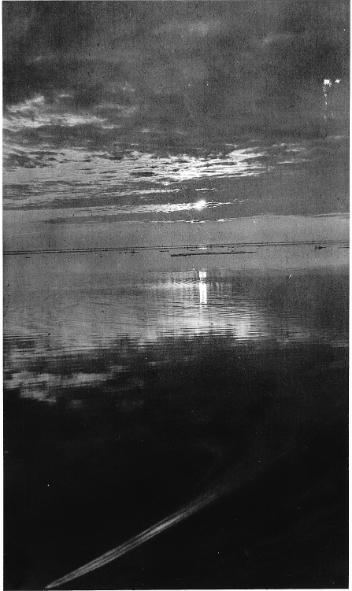 Coucher de soleil à travers les nuages se reflétant sur l'eau, 1921 (?)