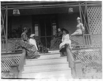 Groupe de femmes et d'enfants non identifiés assis sur une véranda, Drummondville, QC, vers 1895