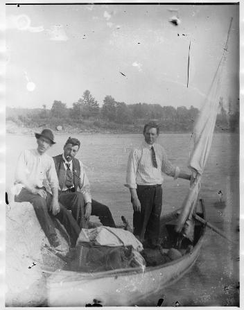 Three unidentified men in a row boat, near Drummondville, QC, about 1900